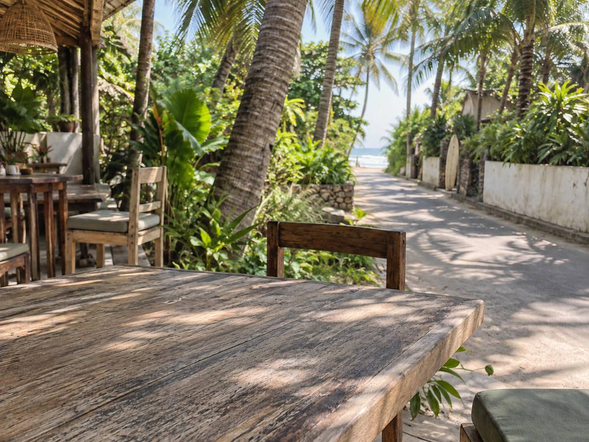 Smoothie bowl with fruit and coconut on a wooden table, Mirissa palm shadow